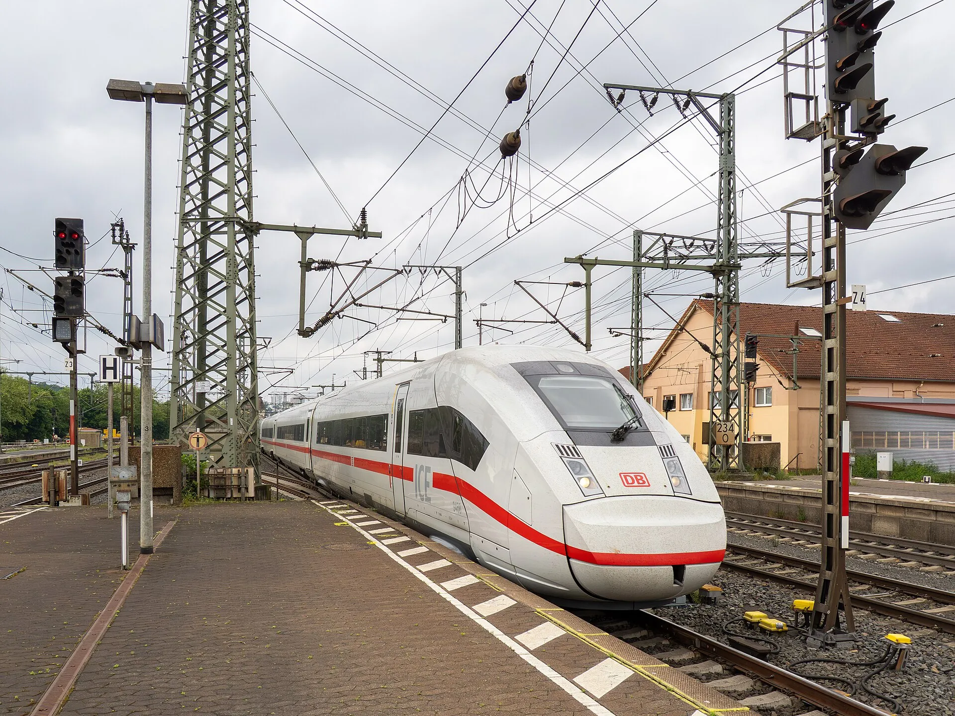 Almanya'da bir tren istasyonu peronunda duran, kırmızı-beyaz renkli Deutsche Bahn ICE yüksek hızlı treninin ön kısmı, üzerinde ICE ve DB logoları görülüyor