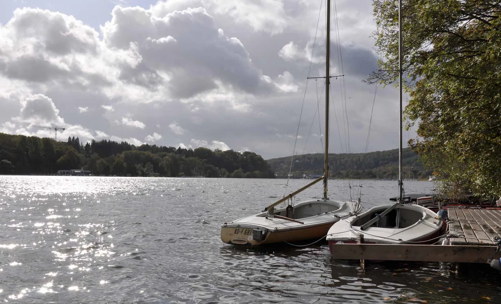 Essen Baldeneysee kıyısında bağlı duran yelkenli tekneler